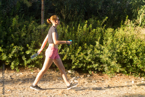 Athletic girl walking in the park © Olga