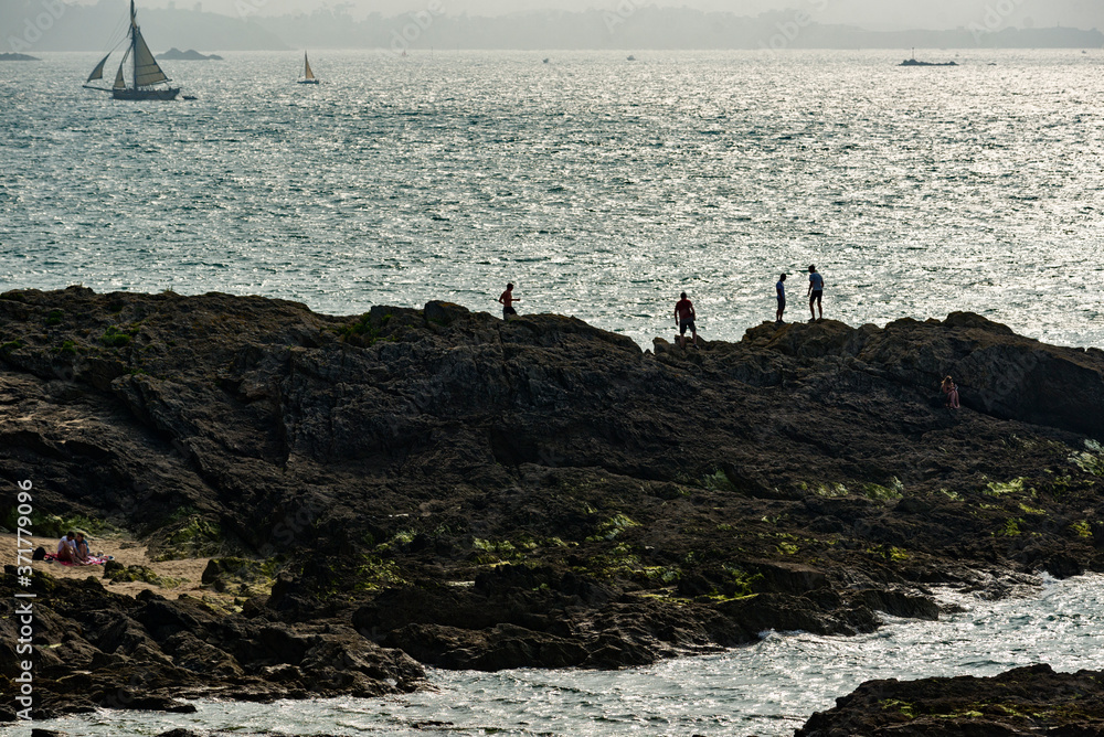 sailboats and rock at sunset in the bay of Saint Malo, Brittany, France