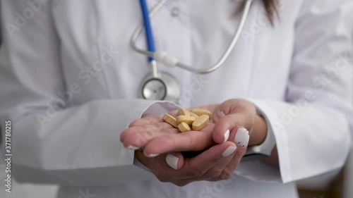 The pills are in the doctor's hands. Hands in medical gloves hold pills. Medicine for the disease. photo