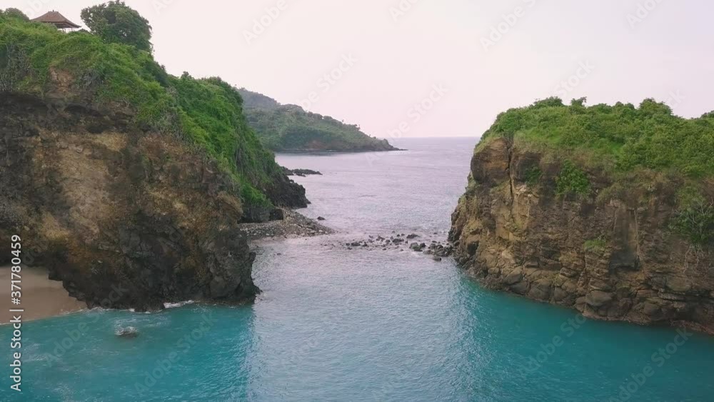 Drone Flight over a hidden exquisite tropical blue lagoon with green cliffs. Prisitine turquoise blue water. Summer paradise destination. Nature, travel and tourism concept. Drone Flight over a hidden exquisite tropical blue lagoon with green cliffs. Prisitine turquoise blue water. Summer paradise destination. Nature, travel and tourism concept.