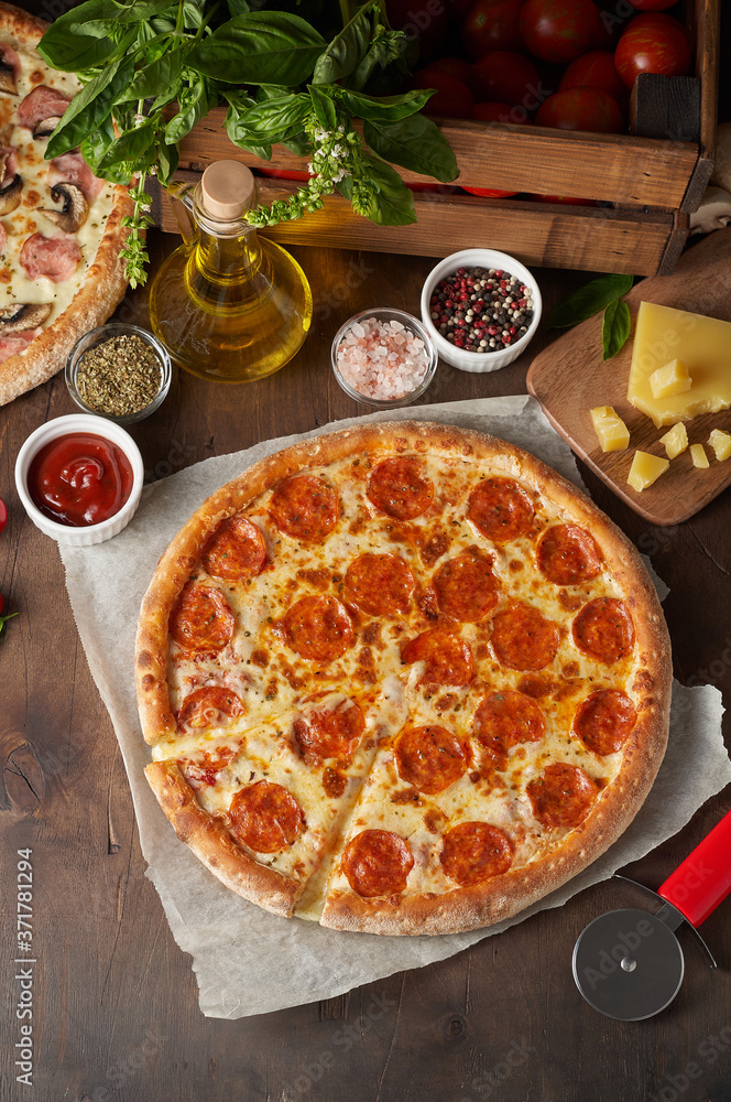 Hot cheese pizza with chorizo on rustic wooden table with ingredients