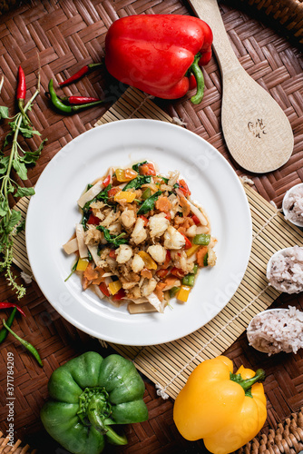 Crab meat fried bell pepper on the wooden background.