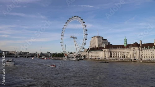 tourists enjoying boat trip along Themes river near Westminster, London (london eye in background)