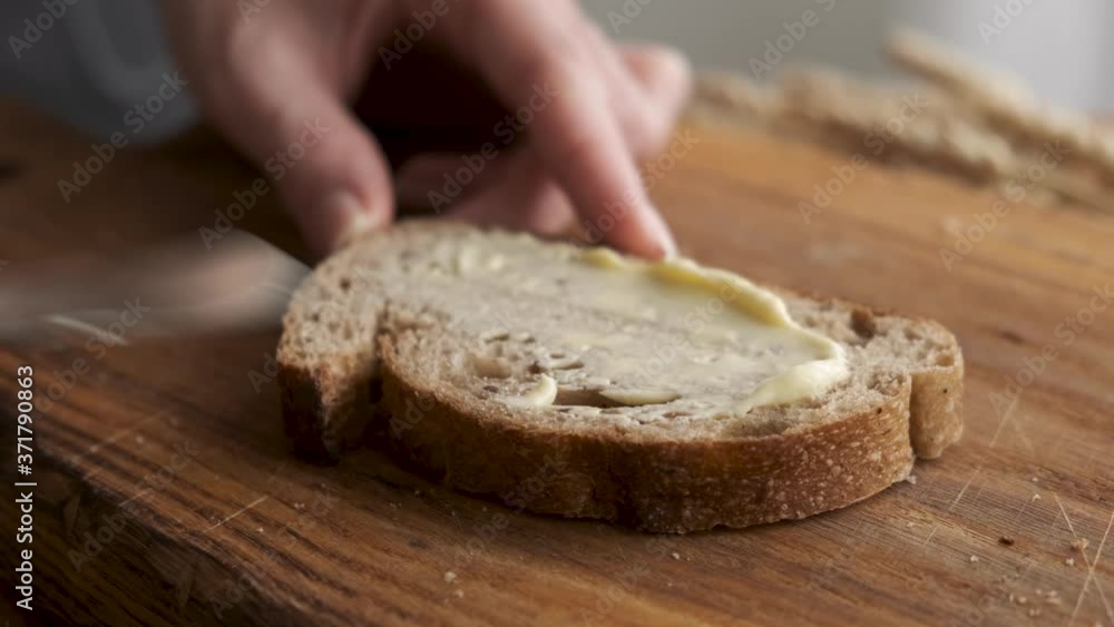 Spreading organic butter on bread. Bread and butter concept. Spreading organic butter on bread. Bread and butter concept.