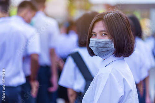 Asian female high school student in white uniform on the semester start wearing masks during the Coronavirus 2019 (Covid-19) epidemic.
