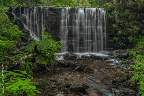 Waterfall on Divoky creek near Kouty nad Desnou village in summer day