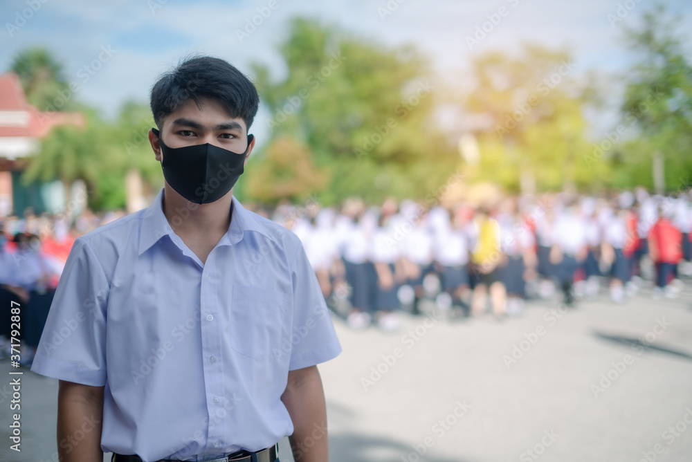 Asian male high school student in white uniform on the semester start wearing masks during the Coronavirus 2019 (Covid-19) epidemic. Asian male high school student in white uniform on the semester start wearing masks during the Coronavirus 2019 (Covid-19) epidemic.