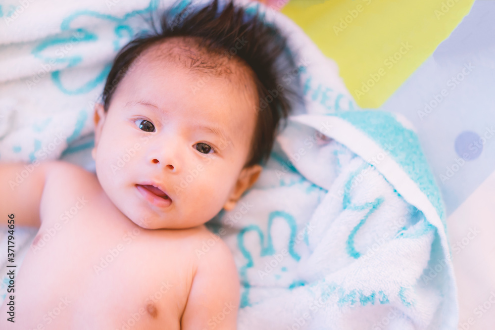 cute little boy is taking off his clothes on the couch after a shower