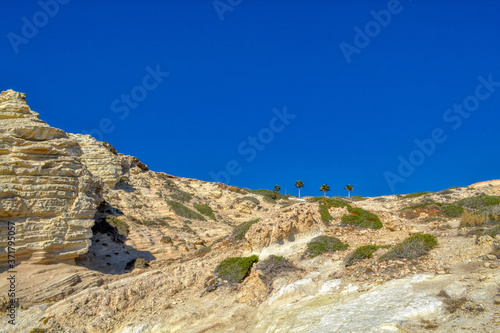 Rocks on the Mediterranean coast in Paphos, Cyprus. Light clay mountains near the sea coastline.