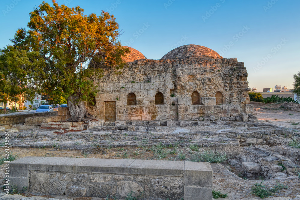 The ruins of medieval baths among the streets of Paphos, Cyprus.  Low ancient buildings with domes built of sand blocks.