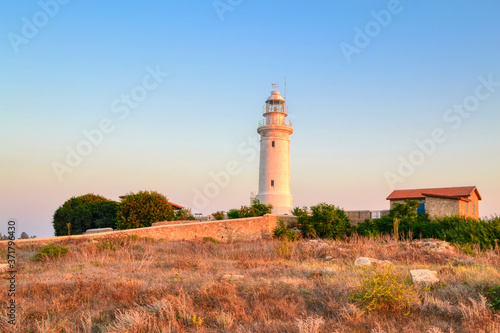 A lighthouse located amidst an archaeological site in Paphos, Cyprus. View of the lighthouse located at Faros Beach at sunset.