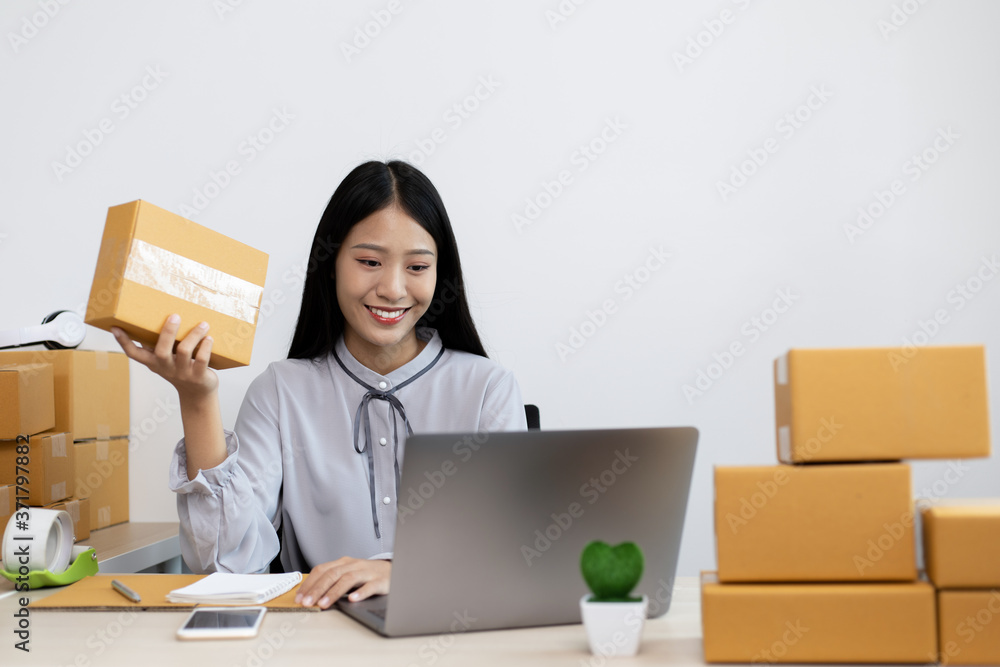 Young Asian woman is selling products online and is confirming an order from a customer. Young Asian woman is selling products online and is confirming an order from a customer.