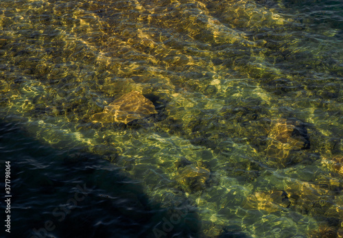 stones are visible through clear water