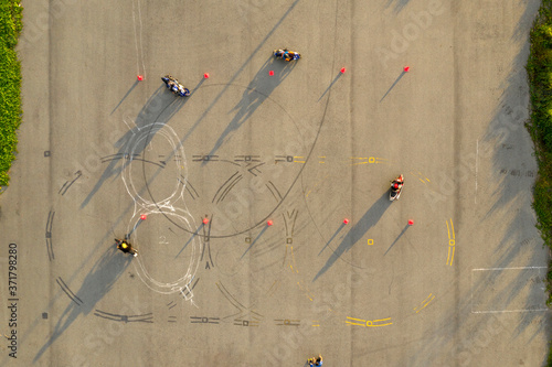 Obraz na plátně top down wide aerial view of four riders having fun on an advanced motorcycle tr