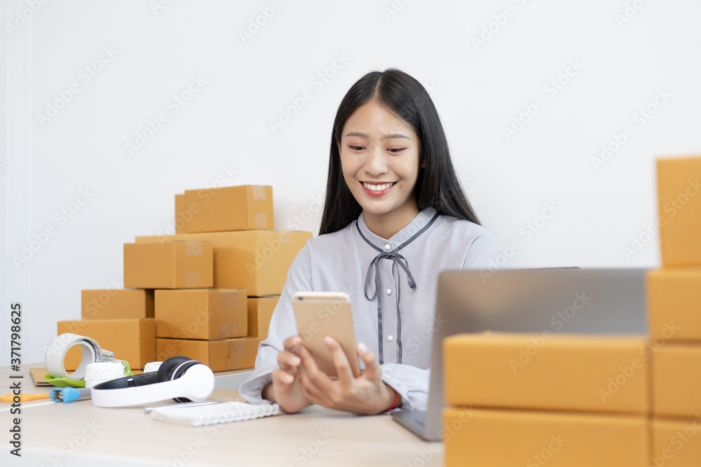 Young Asian woman is selling products online and is confirming an order from a customer. Young Asian woman is selling products online and is confirming an order from a customer.