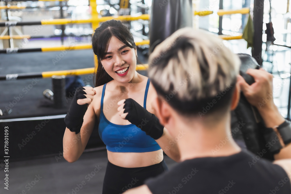 Fototapeta premium Asian couples exercise boxing Punching trainer.Athletic exercises punch.Metaphor Fitness and workout concept exercise Health lifestyle muscle body with take care of your health