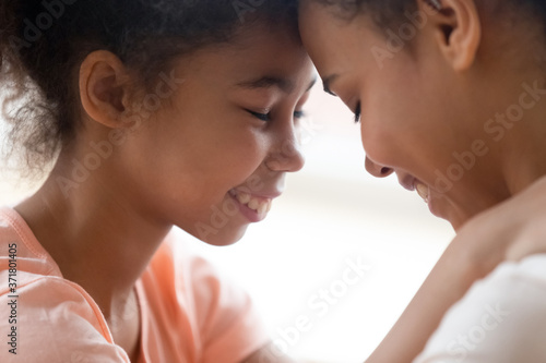 You are my best friend, mommy. Close up shot of happy cuddling african mother and teen daughter standing face to face touching foreheads with closed eyes, supporting one another with tender and love