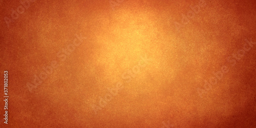 golden abstract shining background with darkening at the edges and glitter from the light in the center. Bright festive background for decoration and banners