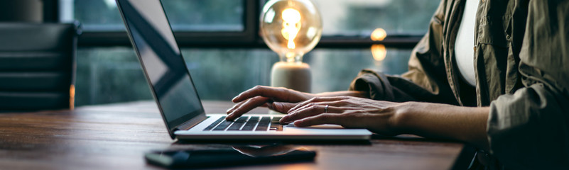 Young woman working with a laptop. Female freelancer connecting to internet via computer. Businesswoman at work