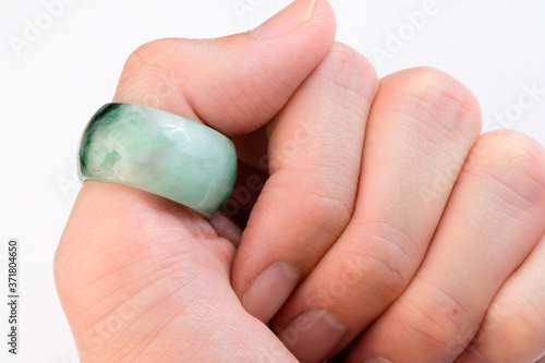 Green jade ring on thumb finger