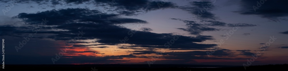 Fototapeta premium Purple-magenta clouds. Tragic gloomy sky. Landscape with bloody sunset. Fantastic skies on the planet earth. Twilight, nightfall. Blackout.