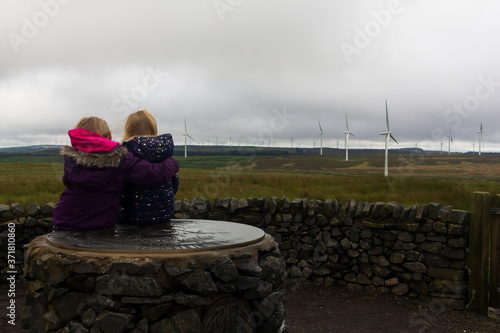Two little childern visiting a wind farm in Scotland on a wet and windy summers day