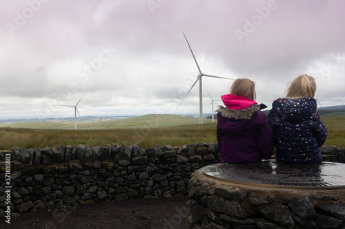 Two little childern visiting a wind farm in Scotland on a wet and windy summers day