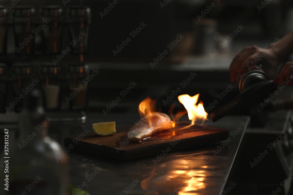 Female chef cooking chicken fillet with manual gas burner in restaurant kitchen, closeup Female chef cooking chicken fillet with manual gas burner in restaurant kitchen, closeup