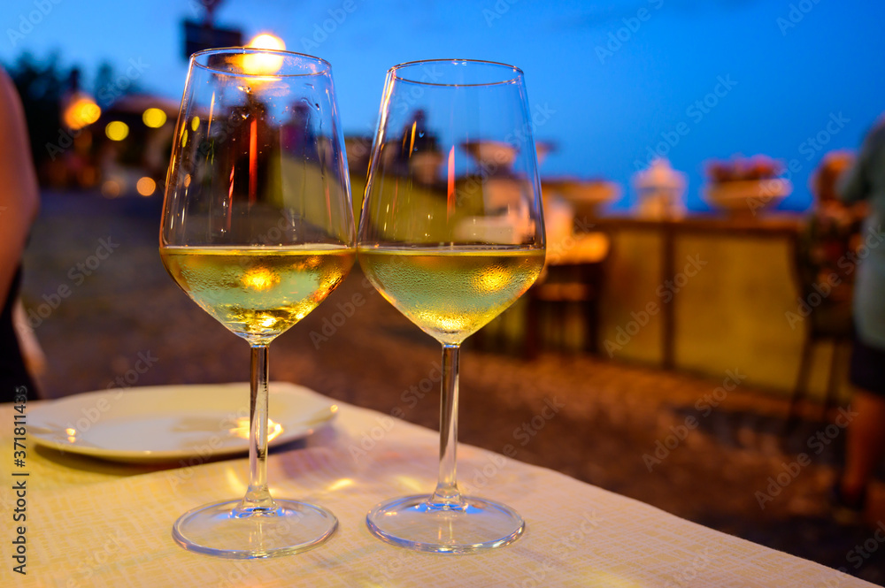 Two glasses of cold dry white wine served outdoor in cafe at night in Italy Two glasses of cold dry white wine served outdoor in cafe at night in Italy