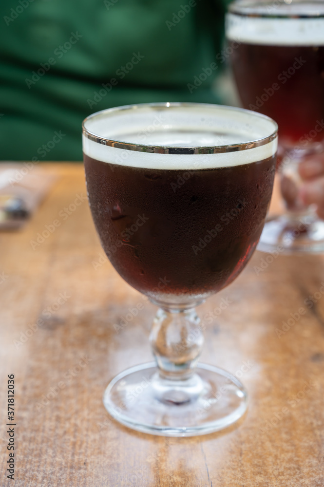 Glasses with cold dark strong Belgian beer served outdoor Glasses with cold dark strong Belgian beer served outdoor