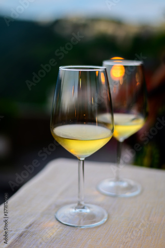 Two glasses of cold dry white wine served outdoor in cafe at night in Italy