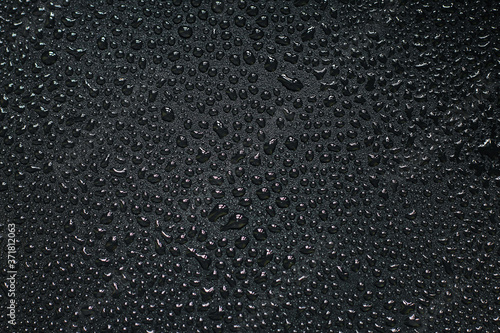 Water droplets on black background. Close-up photo of small water drops on black background.