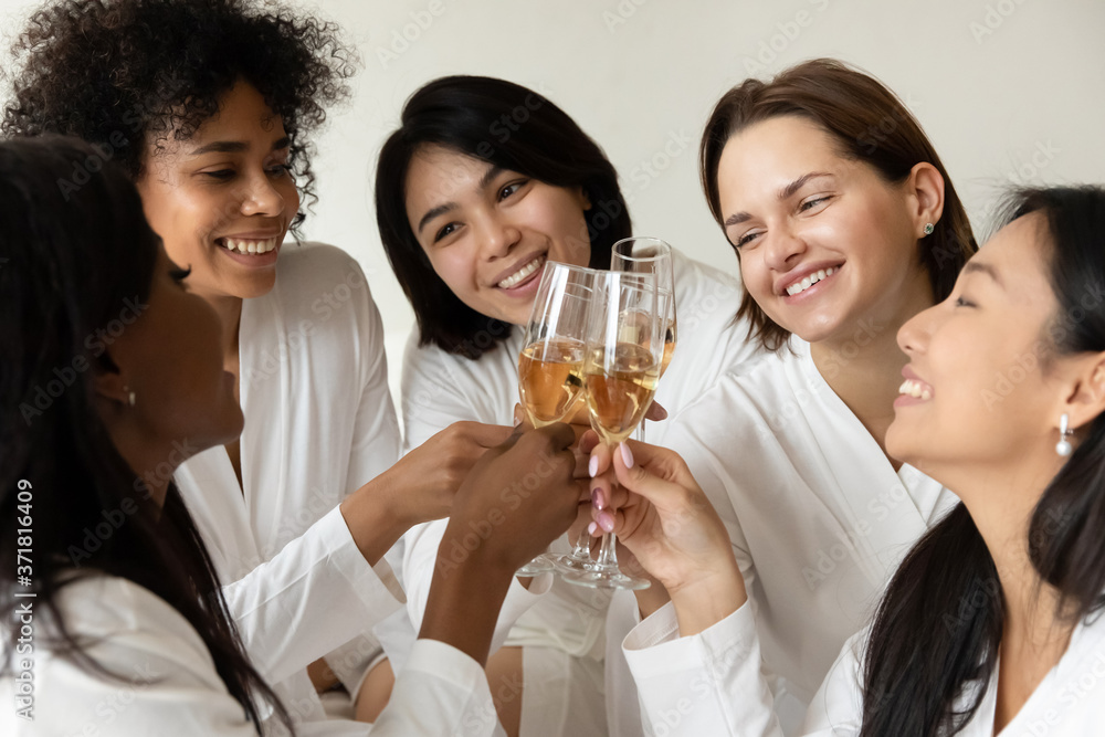 Five multiracial 20s women in bathrobes best friends having fun drinking champagne clinking glasses with sparkling wine celebrating life event enjoy communication luxury bachelorette spa party concept Five multiracial 20s women in bathrobes best friends having fun drinking champagne clinking glasses with sparkling wine celebrating life event enjoy communication luxury bachelorette spa party concept