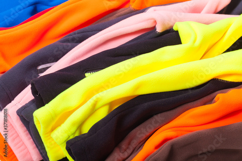 Pile of bright colorful fleece clothes, close-up