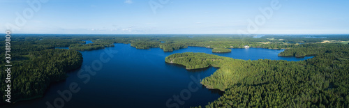 Aerial view of beautiful lake with islands and green forests in Finland on a sunny summer day. Drone photography