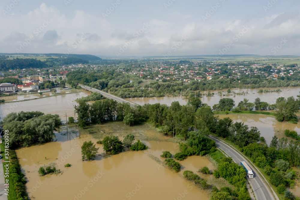 Fototapeta premium Climate change and the effects of global warming. Flooded village, farms and fields after heavy rains. Environmental natural disaster. Concept of global catastrophes in the world