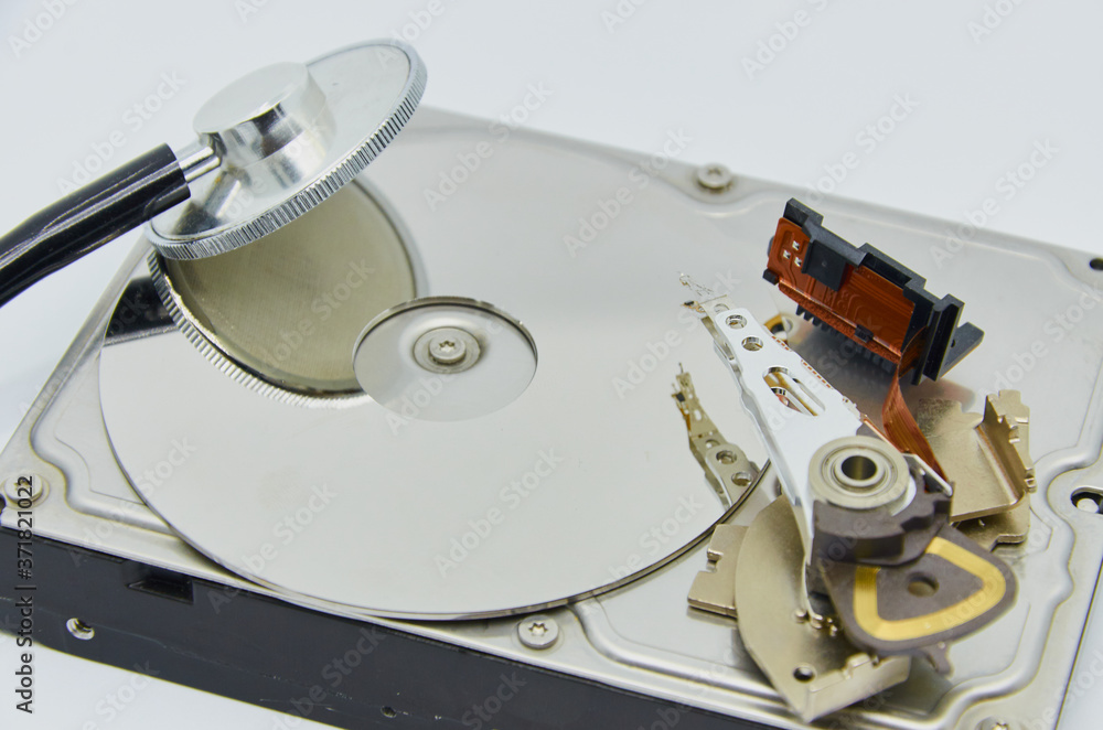 Computer hard drive and a stethoscope. Components for PC. Open hard disk storage. Recovery and storage of information. Magnetic disks inside HDD. Modern digital technology. Computer hard drive and a stethoscope. Components for PC. Open hard disk storage. Recovery and storage of information. Magnetic disks inside HDD. Modern digital technology.