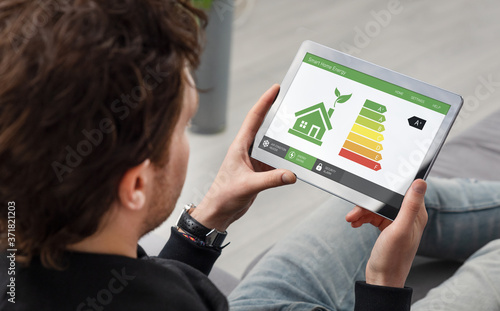 Energy efficiency mobile app on screen, eco house photo