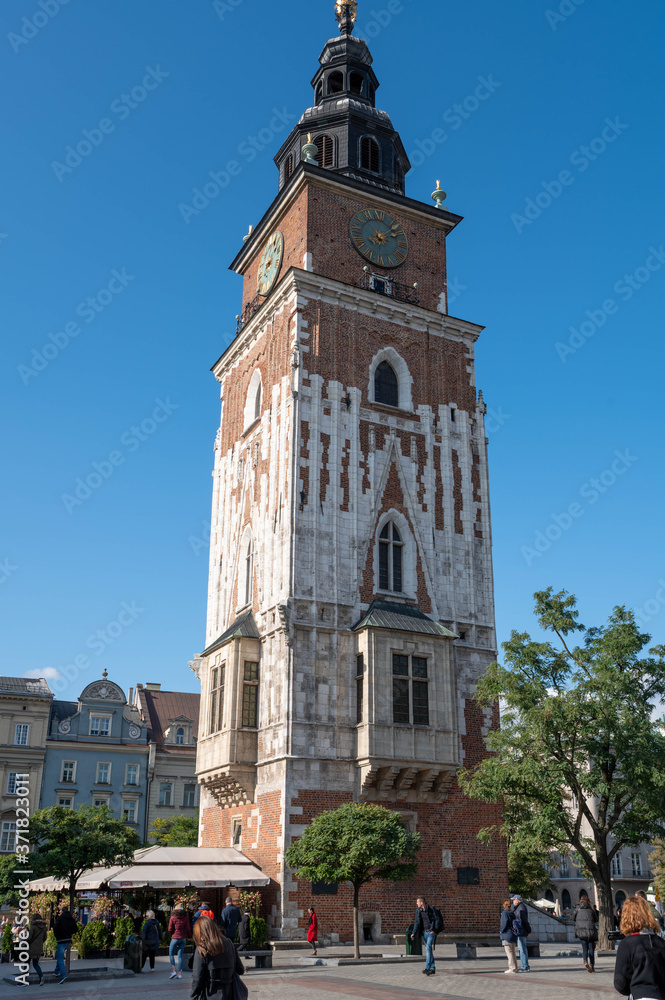 Krakow, Poland. October 9 2019 Pedestrians and tourists mill about at the base of the Town Hall Tower, the clock tower on the Main Square in Old Town Krakow.