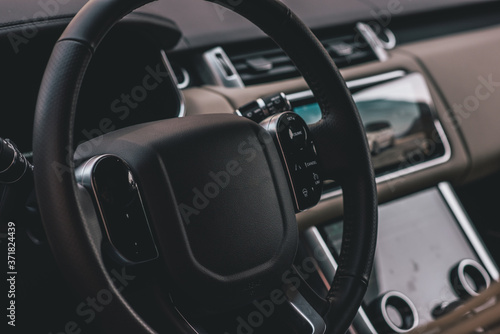 Dark luxury car Interior - steering wheel, shift lever and dashboard. Car interior luxury. steering wheel, speedometer, display, light panels