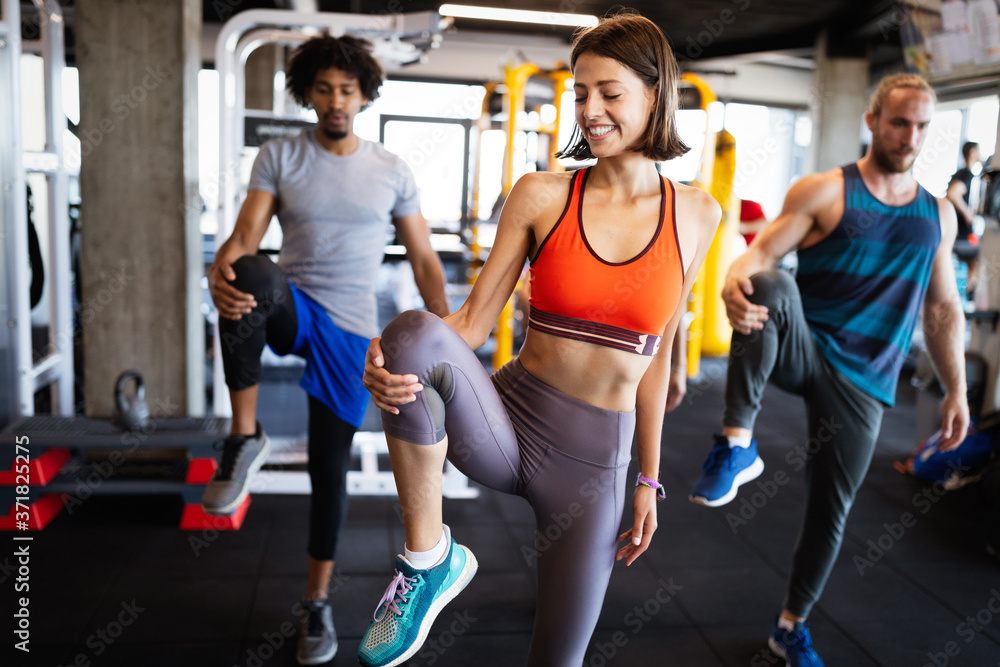 Happy fit friends exercising, working out in gym to stay healthy together Happy fit friends exercising, working out in gym to stay healthy together