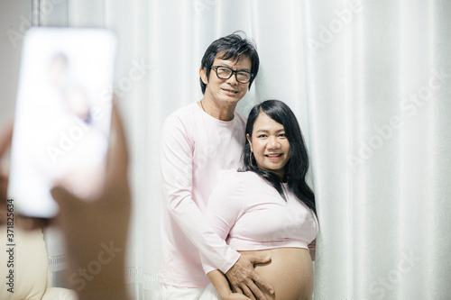 Happiness pregnant woman with husband in relaxation room at home.