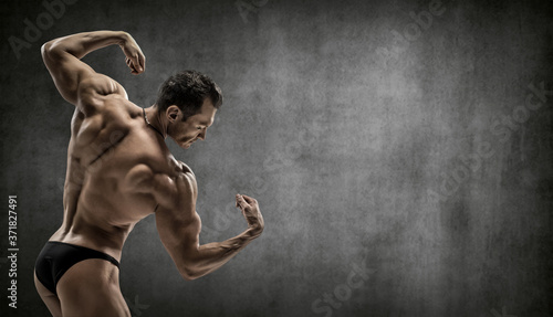 man - bodybuilder pose on grey background