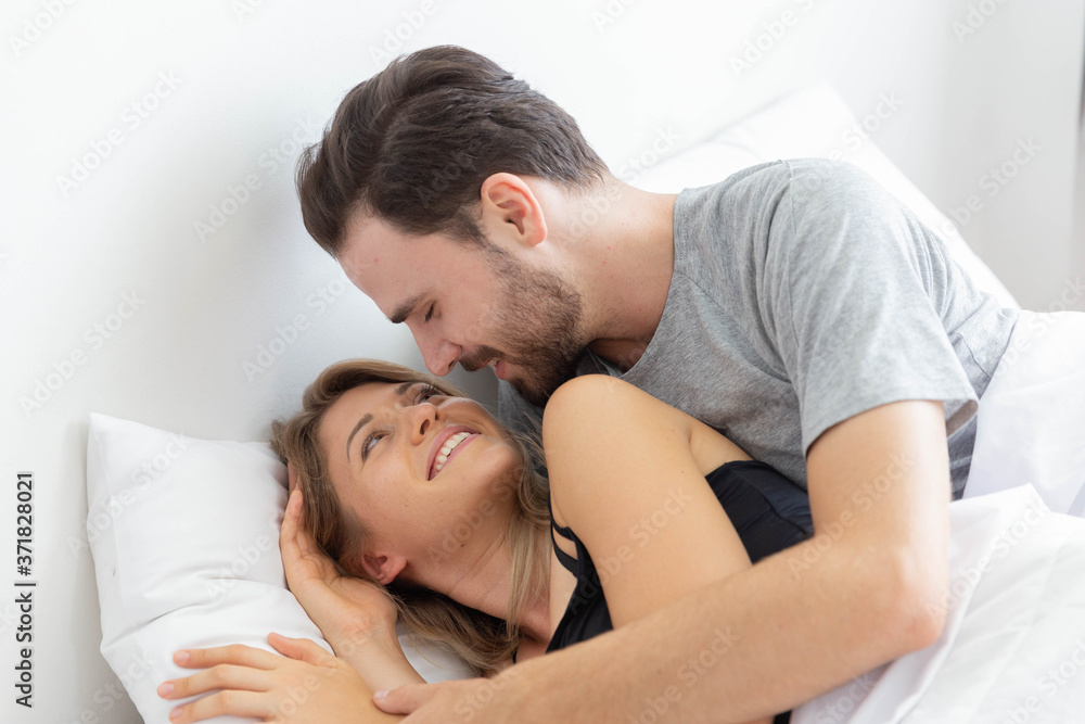 Caucasion couple kiss on bed in bedroom Caucasion couple kiss on bed in bedroom