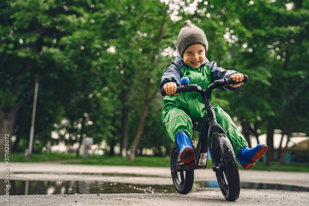 Kids in a puddle. Child having fun outdoors. Boy with bicycle. Kids in a puddle. Child having fun outdoors. Boy with bicycle.