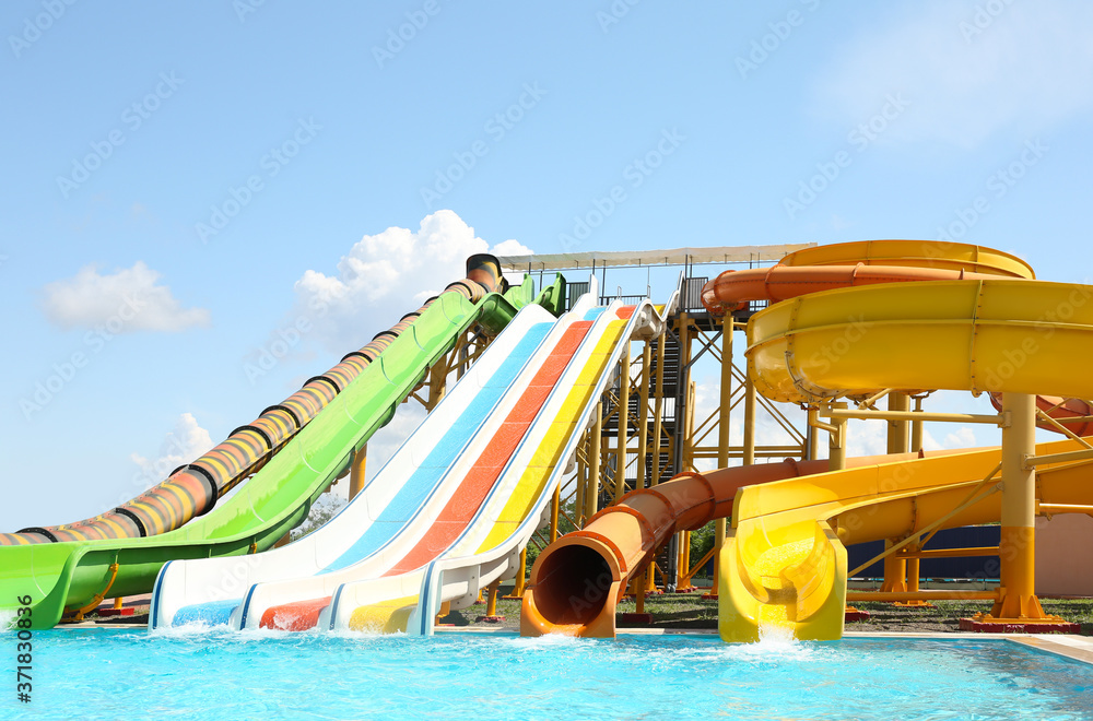 Different colorful slides in water park on sunny day Different colorful slides in water park on sunny day