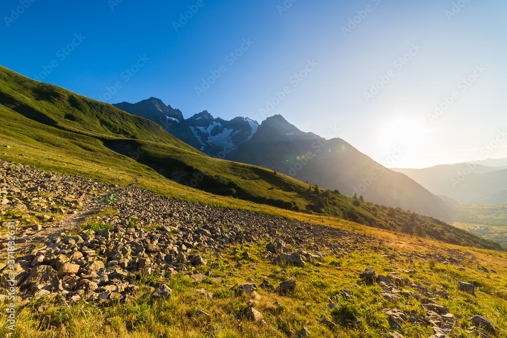 Mountain landscape of the french Alps, Massif des Ecrins. Scenic alpine landscape at high altitude with glacier, green meadows and hiking paths for tourism summer vacation
