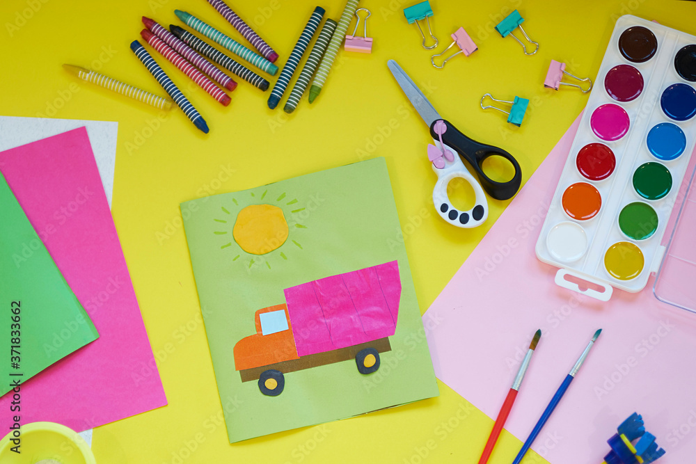 School supplies, stationery on yellow background - space for caption. Child ready to draw with pencils and make application of colored paper. Top view.