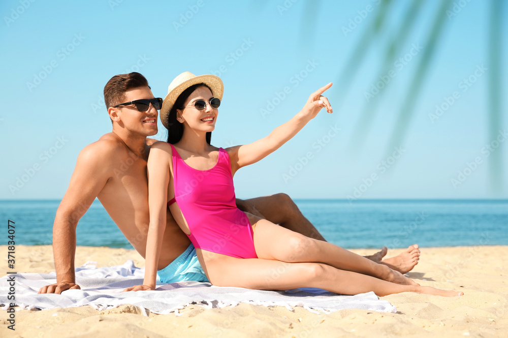Happy couple resting on sunny beach at resort Happy couple resting on sunny beach at resort