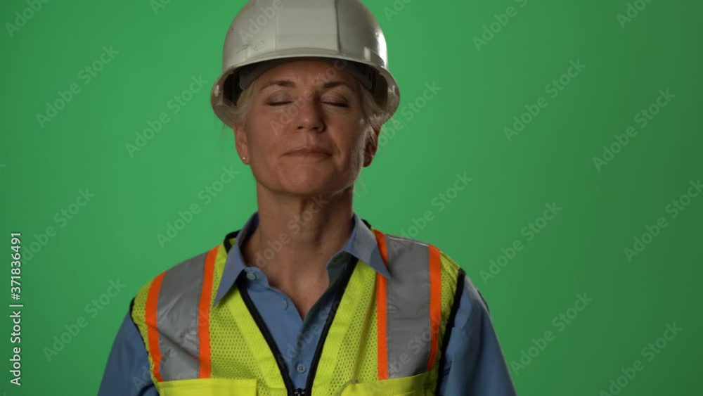 Woman engineer architect on construction site putting on protection medical face mask wearing hard hat and green reflective safety vest on green screen. Woman engineer architect on construction site putting on protection medical face mask wearing hard hat and green reflective safety vest on green screen.